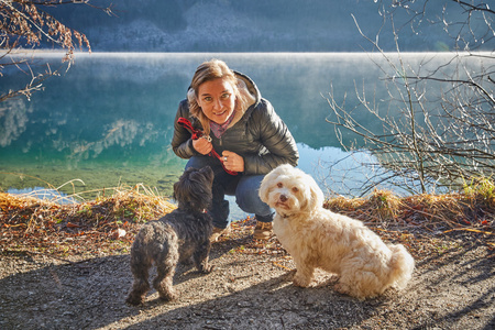 女人和狗在湖奥芬湖在阳光明媚的冬日