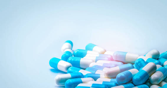 选择性聚焦蓝白胶囊丸在白色背景下与阴影传播。全球医疗保健理念。抗生素耐药性。抗菌胶囊丸。制药行业
