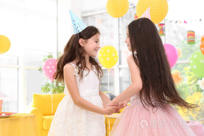 可爱的女孩一起玩在生日聚会室内