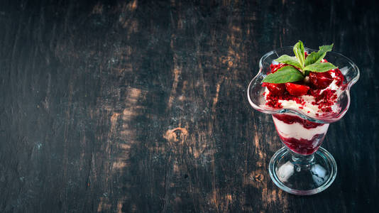 草莓奶油甜点与薄荷。在一个木质的背景。顶部视图。复制空间