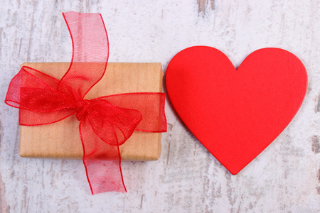 包装的礼物，情人节和红色的心在旧的木制瓷砖上