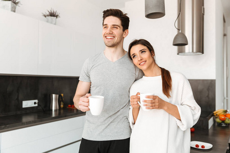一个幸福的年轻夫妇的肖像在厨房喝咖啡在家中