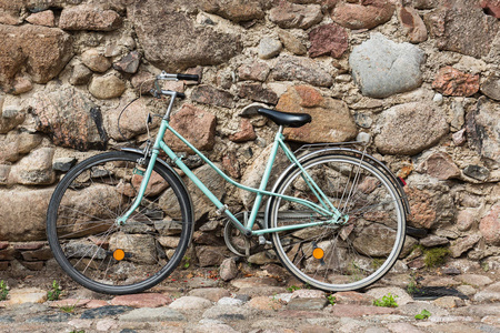 旧的蓝色生锈的自行车对旧墙上的街道上。复制空间