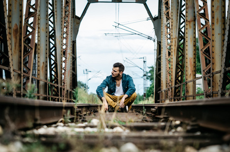 男子坐在铁路桥梁