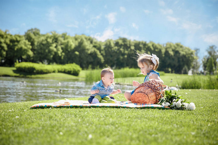 两个快乐的孩子坐在公园野餐。自然的兄妹