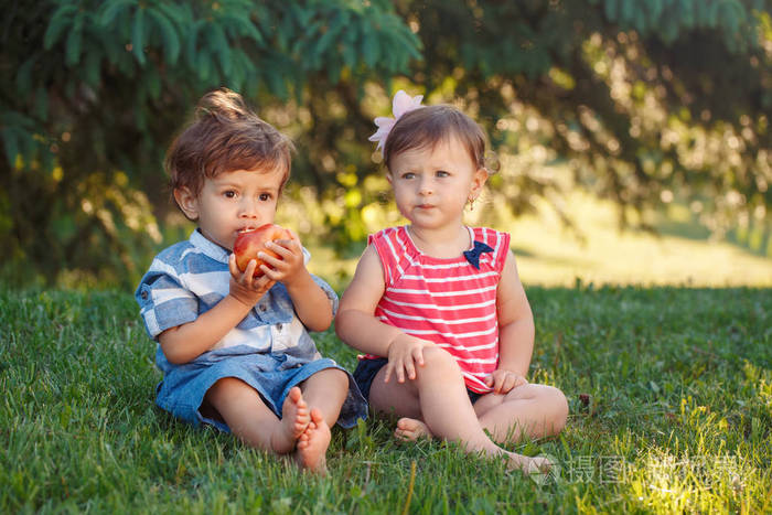 两个白人白种人可爱可爱有趣的孩子们坐在一起分享苹果食品组肖像。羡慕友情的童年概念。最好的朋友永远的男孩和女孩