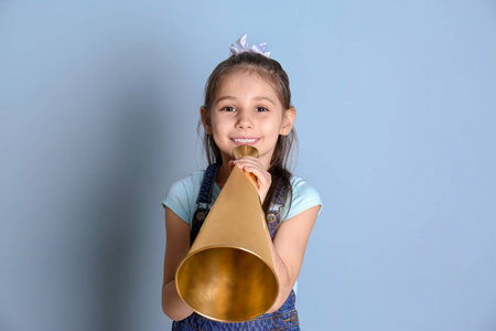 可爱的小女孩,用扩音器对颜色背景照片