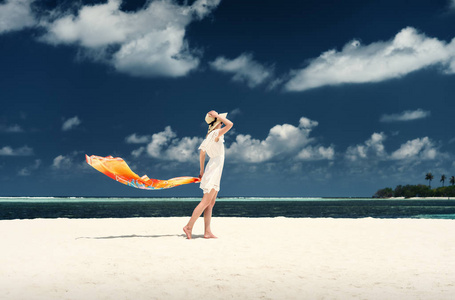 一个女孩在白色衣服上岛的海岸。马尔代夫。白色的沙滩。Guraidhoo