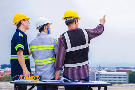 并指向建筑工地, 良好的团队合作和工程主题照片