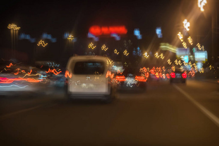 抽象模糊移动白车和快速驾驶交通在城市夜间, 明亮的刹车灯