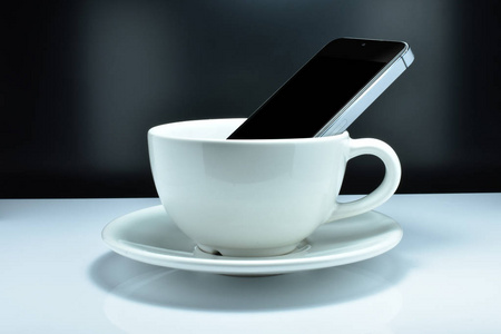 智能手机是在咖啡杯。概念有些人喜欢使用智能手机，同时喝咖啡