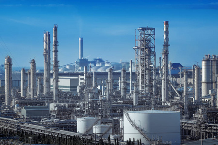 天然气蒸馏塔与石油工业厂房烟气堆积在化石石油厂下游蓝天背景下