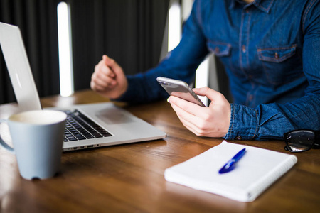 关闭了手一心多用的人用笔记本电脑和手机连接 wifi,笔记本和咖啡的杯