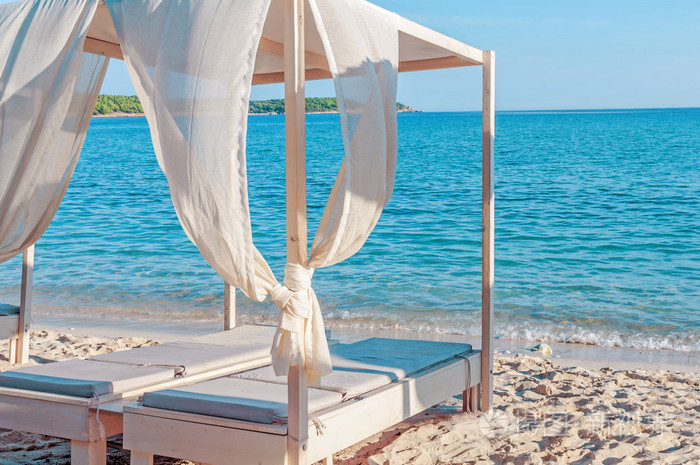 在一片蓝天的绿松石海木日光浴浴床