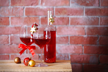 瓶红酒和眼镜上的背景墙上的圣诞礼物