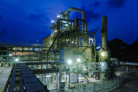 工业生产环境用管道和管架在黄昏时间的化学工业生产工厂照片