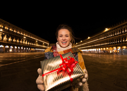 在威尼斯圣马克广场上的圣诞礼品盒幸福女人