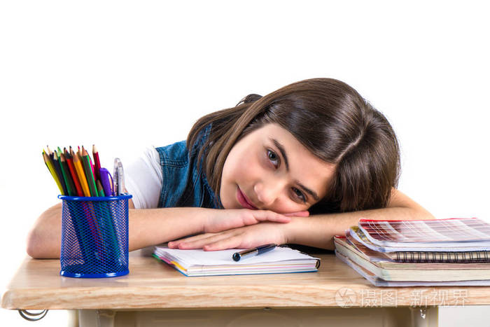 一个美丽的学校女孩坐在书桌前思考.白色 bac