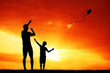 父亲和儿子一起在日落的风筝