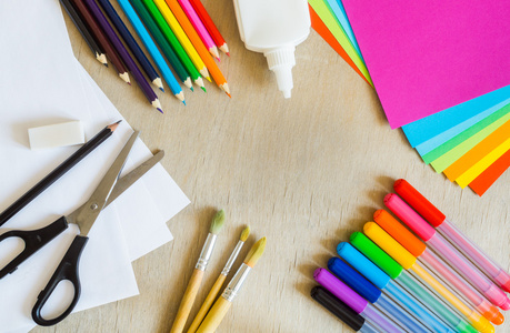彩色的纸，毡尖笔，铅笔，刷上木制背景