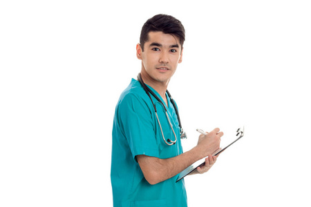 美丽年轻的黑发男医生穿着制服，在听诊器摆姿势孤立在白色背景上的肖像
