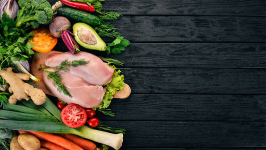 鸡胸肉和新鲜蔬菜。健康食品。在黑色的木质背景。顶部视图。复制空间