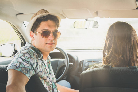 年轻的时髦家伙的肖像与他的女朋友在车上