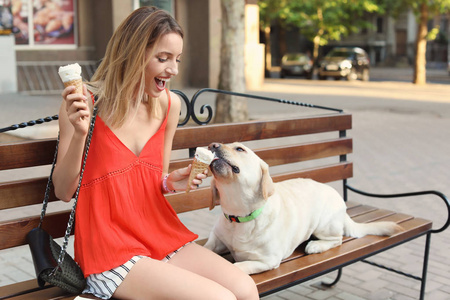 业主对待她的黄色拉布拉多猎犬与冰淇淋户外