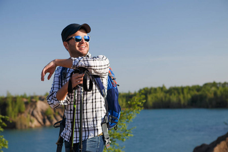 湖边山上有手杖的旅游男子照片