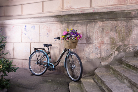 一篮鲜花在老墙上的复古自行车