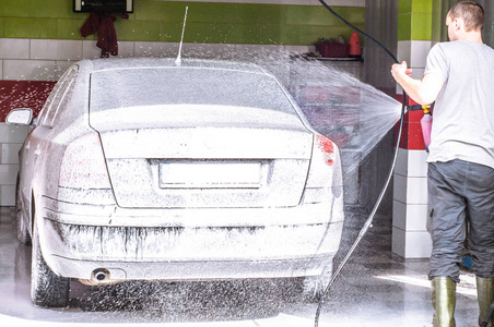 一个人洗一辆车在车库里