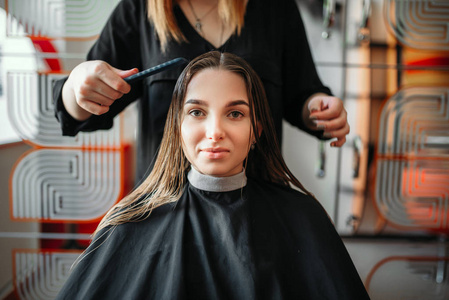 妇女在美发沙龙, 女设计师用剪刀和梳子在手上的背景。美容工作室的发型制作