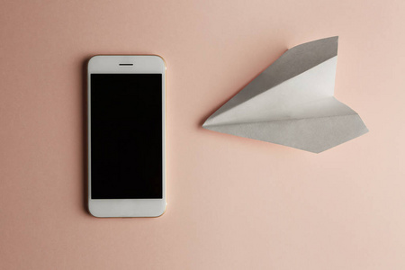 智能手机与平躺在白色的纸平面和空白纸的粉彩粉红色的背景。概念水平
