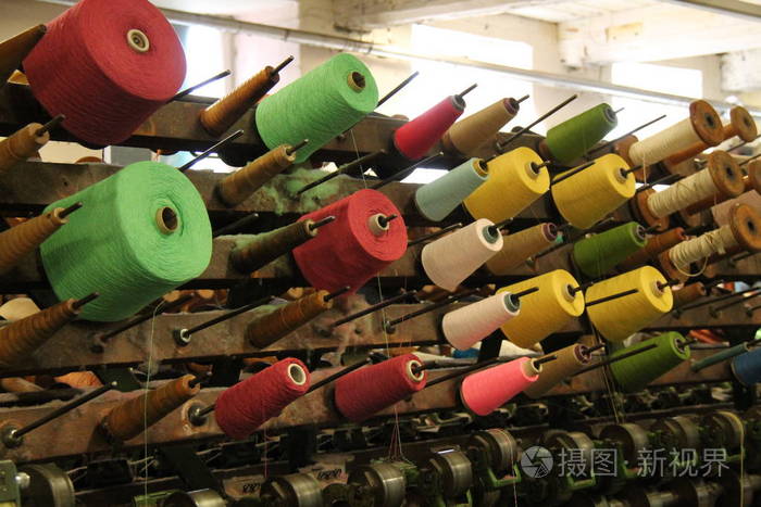 老式纺织机器上的彩色棉卷轴