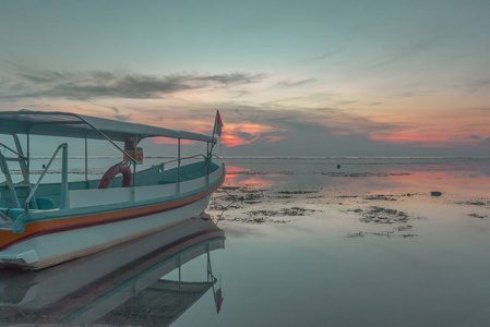 一艘印尼小型客船在日出时, 倒影在水中, 沙努尔, 巴厘岛, 印度尼西亚, 2018年4月21日