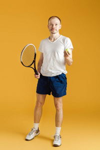 年轻的网球运动员打网球在黄色背景上