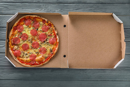 木桌上有美味比萨的纸板箱
