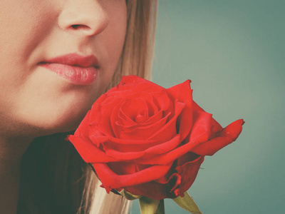 握红玫瑰靠近脸的特写女人