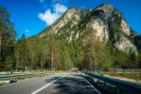 美丽的山路与树木, 森林和山脉的背景。在意大利白云岩山州公路公路上拍摄