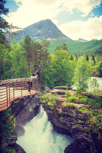 在挪威，欧洲的旅游胜地。女摄影师拍照相机 Gudbrandsjuvet 的观点，Valldalen 谷，Valldal 和罗斯蒂