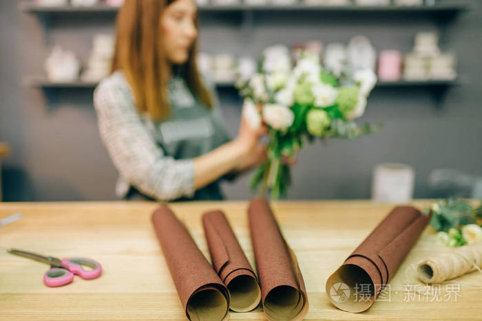 女花店装饰鲜花的构图。花卉生意, 花束准备过程, 材料和工具为装饰在桌上