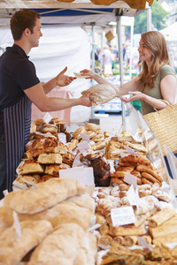 从市场摊位买面包的女人照片