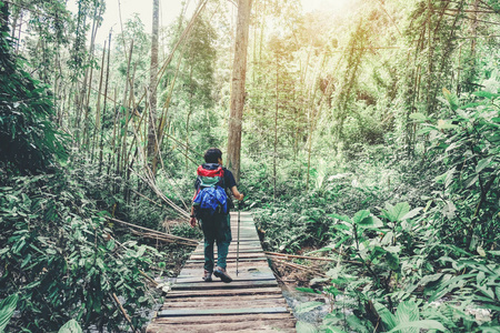 旅游和旅行者与背包横渡山河在森林里