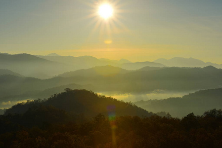 美丽的天空和金色的云彩.日出前的群山.清晨.太阳从山顶升起照片