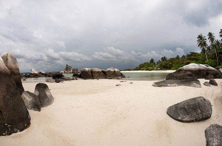 天然岩石地层中海和中勿岛，印度尼西亚的棕榈树的白色沙滩上