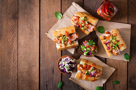 热狗三明治与墨西哥萨尔萨在木制背景。