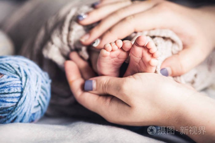 幸福的家庭观念婴儿脚在母亲的手妈妈和她的孩子美丽的母性概念形象