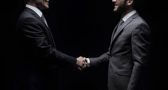 两个性格开朗的商人握手，看着对方