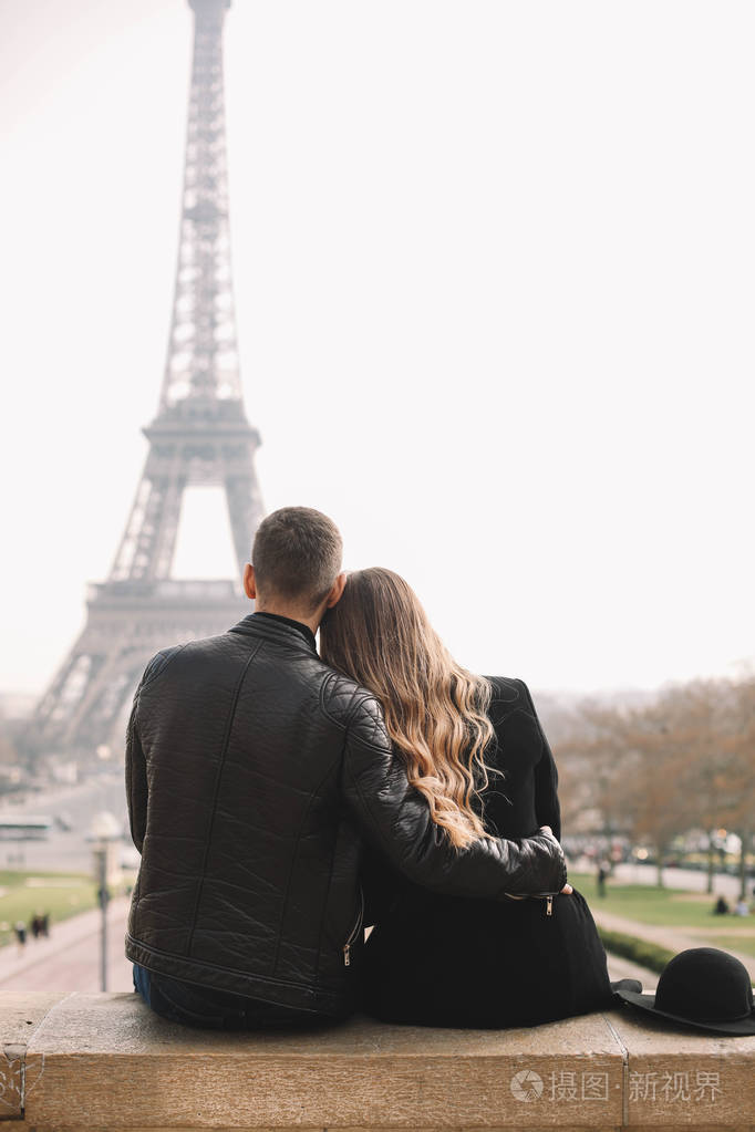 浪漫的情侣坐在埃菲尔铁塔的背景