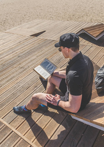 欧洲人, 一个穿黑衬衣的学生, 一顶在城市公园里看书的帽子, 靠近河边。
